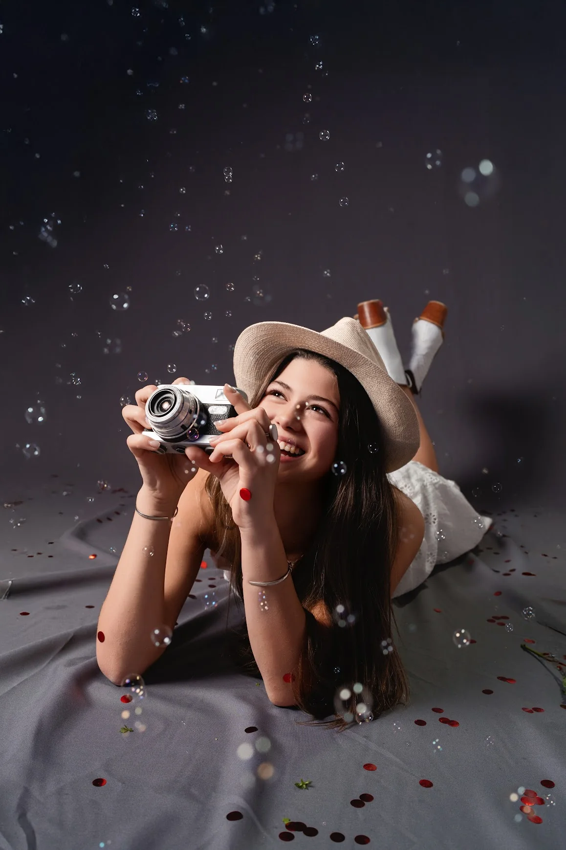 Una quinceañera con sombrero y cámara durante una producción de Jema